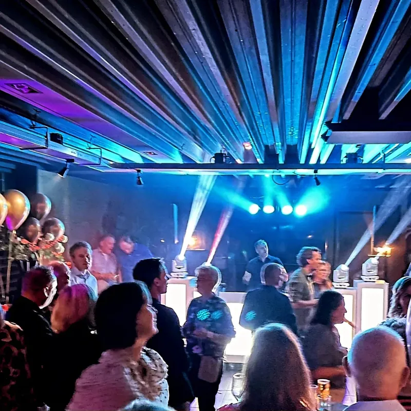 Publiek onder krachtige lichtstralen in een feestzaal