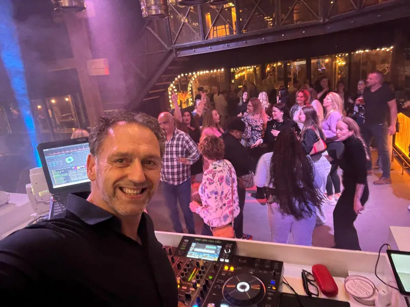 DJ Deliso met dansende gasten op de achtergrond